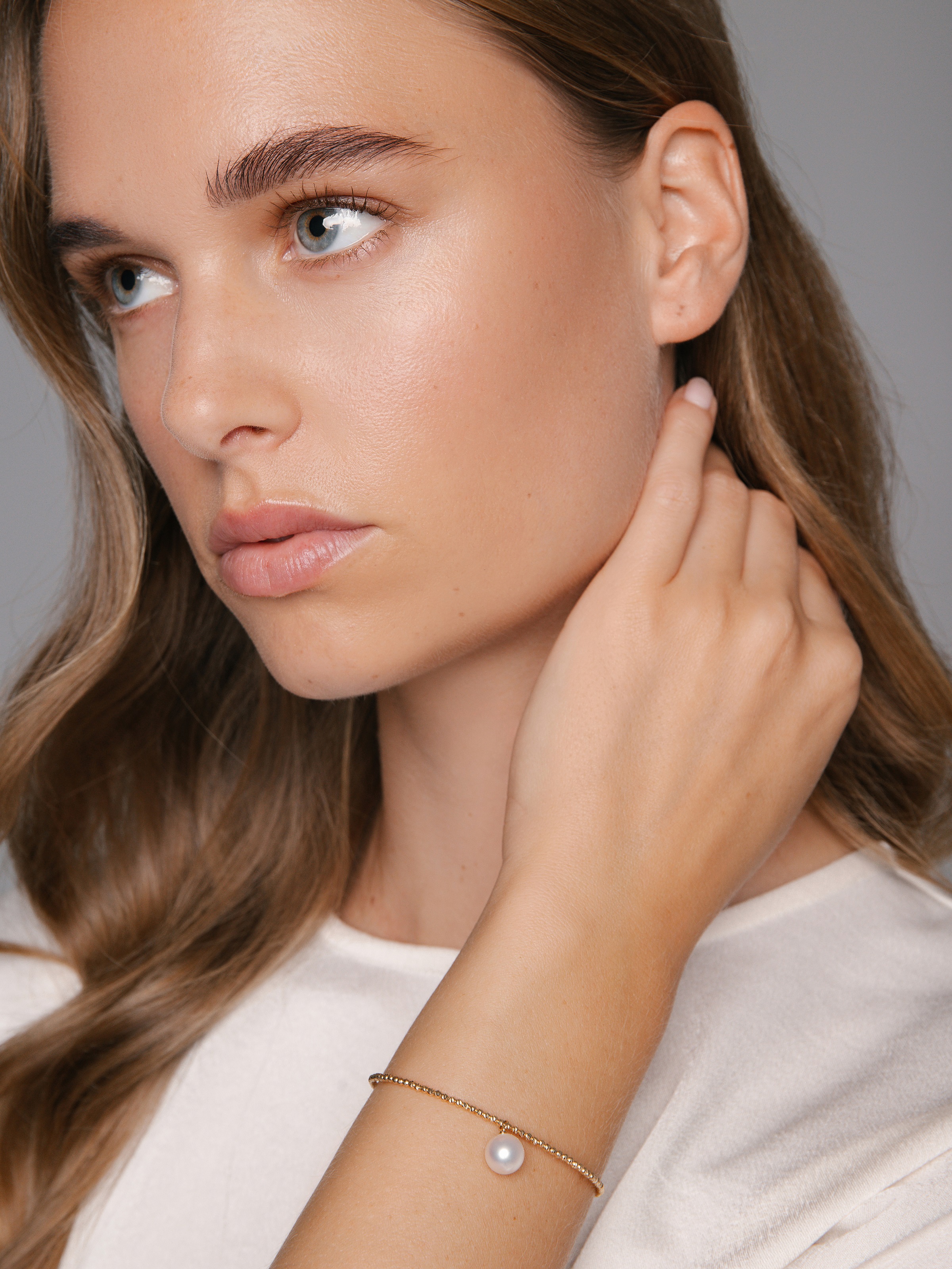 Eleganter Armreif mit einzelner Perle und Goldkettchen